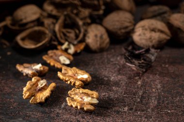 Koyu renkli bir masada ceviz ve ceviz taneleri.