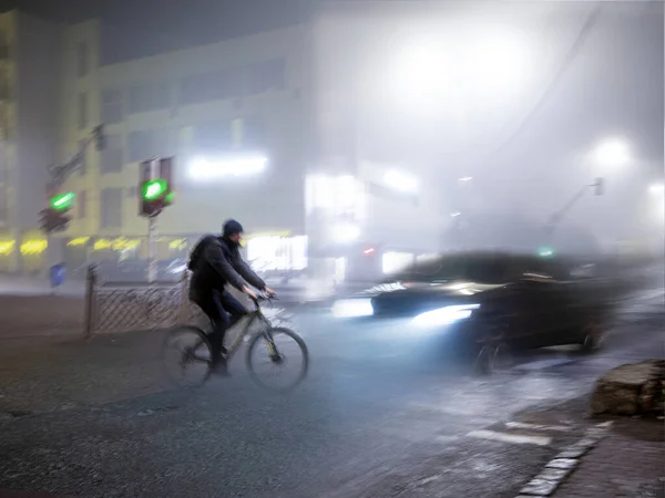Cyclist on zebra crossing in the evening. Dangerous situation. Intentional motion blur