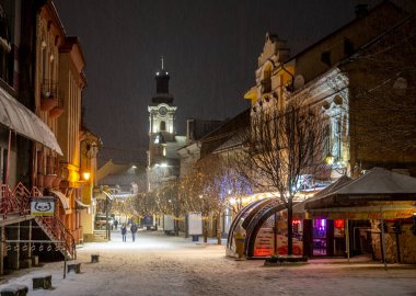 UZHOROD, UKRAINE - 16 HAZİRAN 2021: Ukrayna 'da geceleri karla kaplı Uzhhorod şehri manzarası. Voloshyna şehrin merkezi caddesidir.
