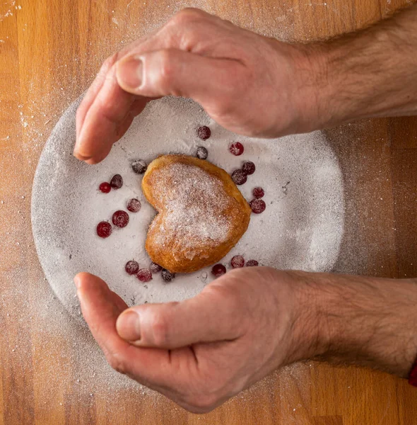 Homemade food concept. Heart-shaped donut on a wooden table