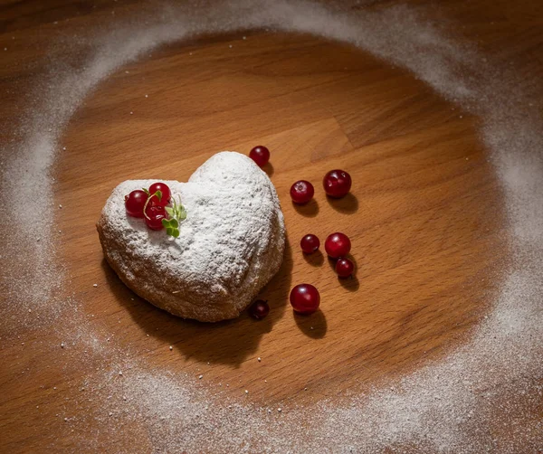 Homemade food concept. Heart-shaped donut on a wooden table