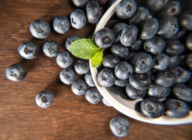 Ahşap arka planda bir tabakta yaban mersini. Olgun ve sulu taze yaban mersini.