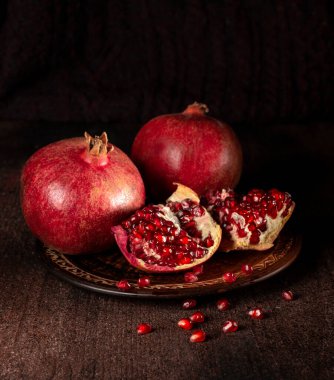 Ahşap zemin üzerinde bir tabakta nar.