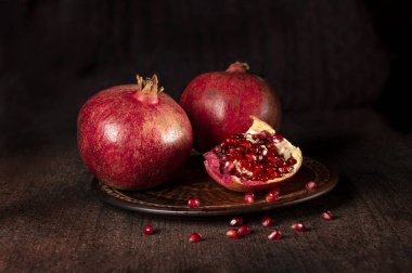 Ahşap zemin üzerinde bir tabakta nar.