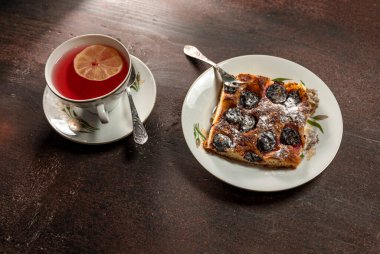 Tahta bir masada limonlu ve erikli bir fincan çay.