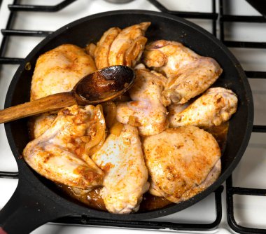 Gaz ocağındaki tavada tavuk kanadı hazırlıyorum.