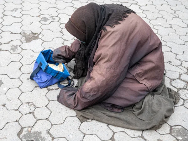 貧しい老婦人は街の通りで施しを請う — ストック写真