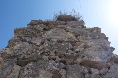 Taş bir duvarın dokusu. Mavi gökyüzüne karşı eski antik taş duvar