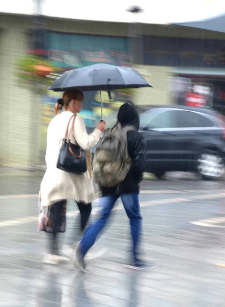雨の日に傘を持って通りを歩いている女性 意図的な動きのぼかし 専用画像 — ストック写真