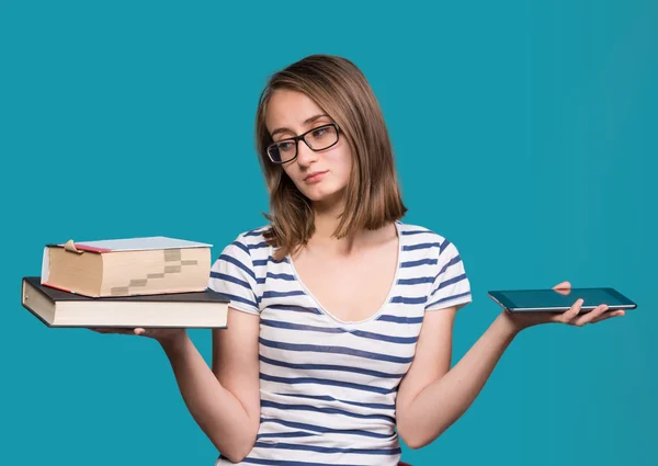 Young girl  holding a book in one hand and a tablet-pc in the ot — Stock Photo, Image