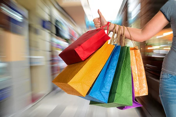 Vrouw met duim omhoog en bedrijf shopping tassen — Stockfoto