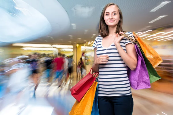 Młoda dziewczyna uśmiechający się z torby na zakupy — Zdjęcie stockowe