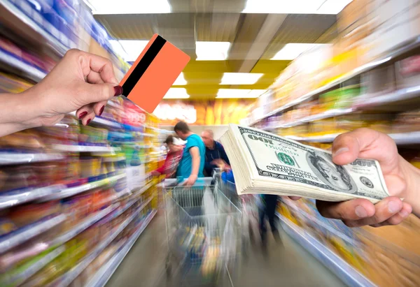 Woman holding credit card, man holding stack of dollar bills — Stock Photo, Image