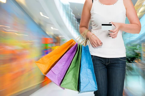 Mujer sosteniendo bolsas de compras y tarjeta de crédito — Foto de Stock