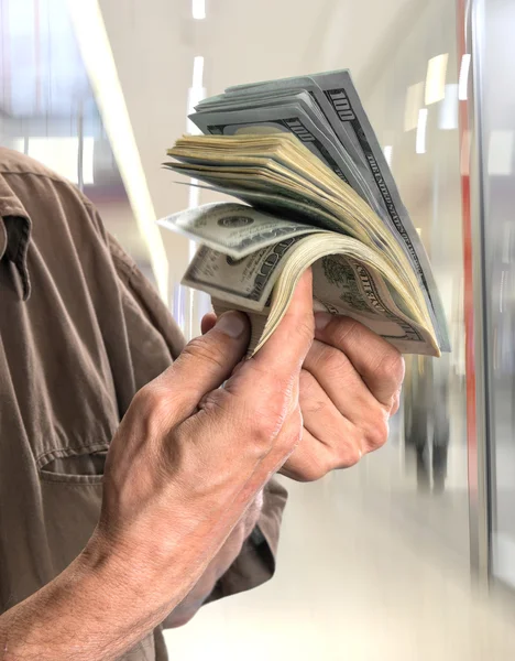 Uomo in possesso di pila di banconote in dollari — Foto Stock
