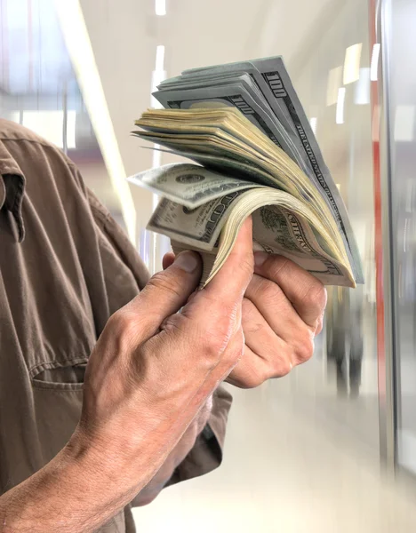 Hombre sosteniendo pila de billetes de dólar — Foto de Stock