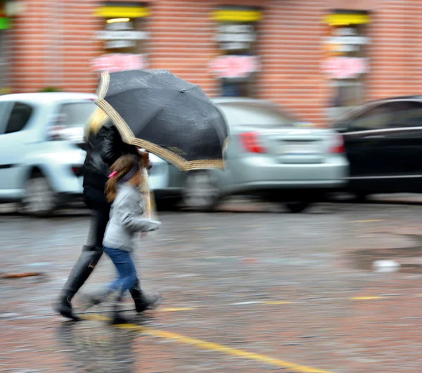 Люди идут по улице в дождливый день — стоковое фото
