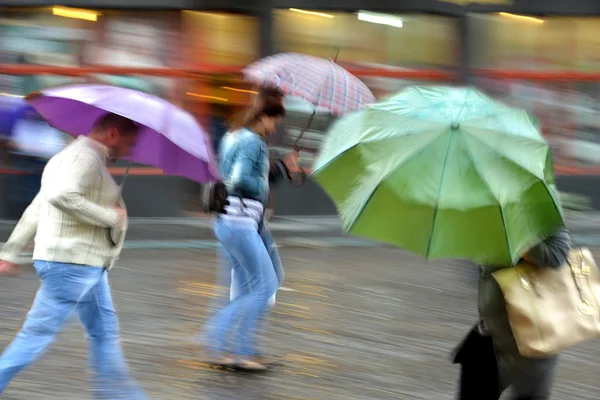 Люди, що йдуть по вулиці в дощовий день — стокове фото