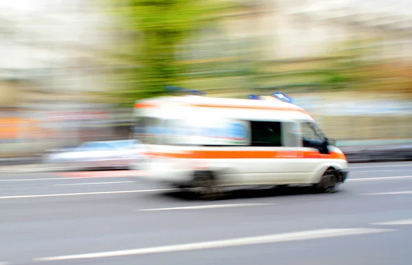 Ambulancia en movimiento conduciendo por el camino — Foto de Stock