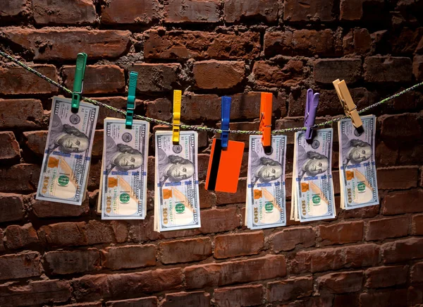 Dollar bills and credit card hanging on a rope — Stock Photo, Image