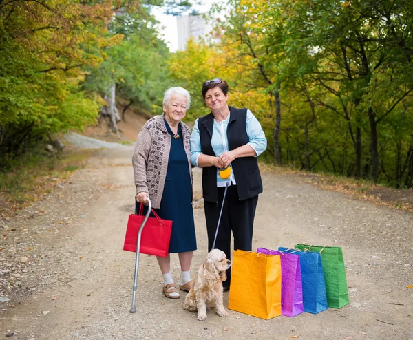 Två kvinnor står med kassar och påsar — Stockfoto