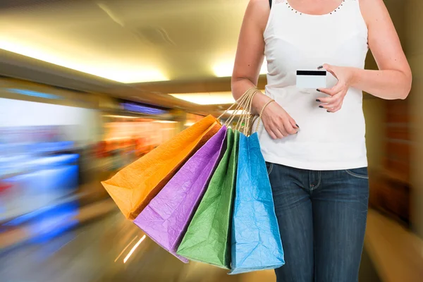 Woman holding shopping bags and credit card — Stock Photo, Image