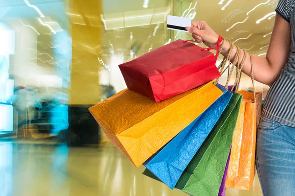 Mulher segurando sacos de compras e cartão de crédito — Fotografia de Stock