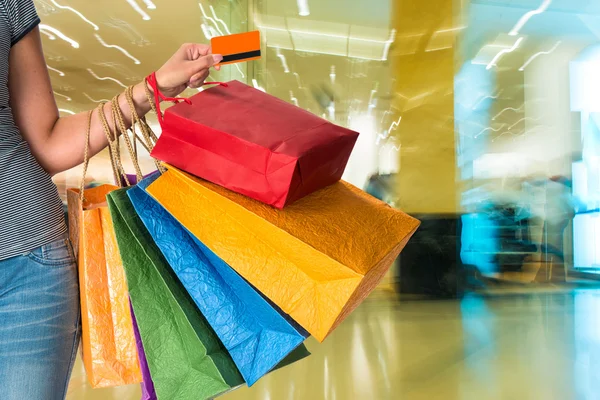 Femme tenant des sacs à provisions et carte de crédit — Photo