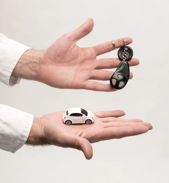 Hombre sosteniendo llaves y coche pequeño — Foto de Stock