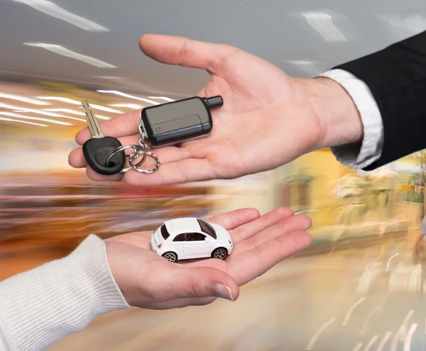 Man holding small car key, woman holding small car — Stock Photo, Image