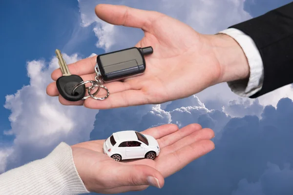 Man holding small car key, woman holding small car — Stock Photo, Image