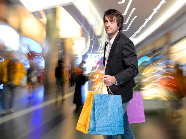 Joven guapo con bolsas de compras — Foto de Stock