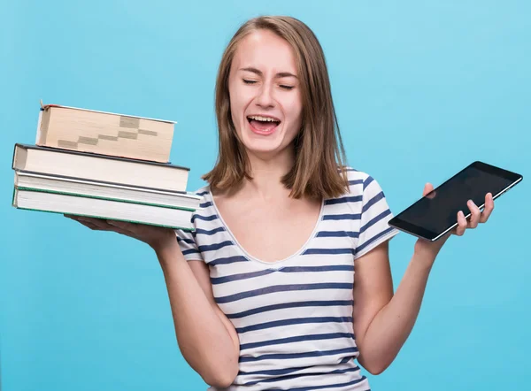 Jovencita sosteniendo un libro en una mano y una tableta-PC en el otro —  Fotos de Stock