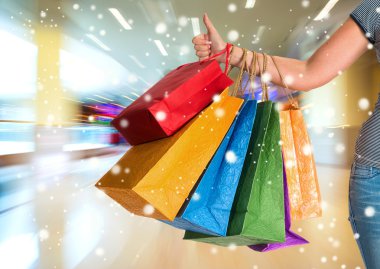 gösterilen kadın başparmak yukarıya ve holding alışveriş torbaları