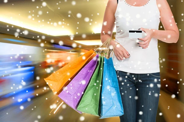 Mulher segurando sacos de compras e cartão de crédito — Fotografia de Stock