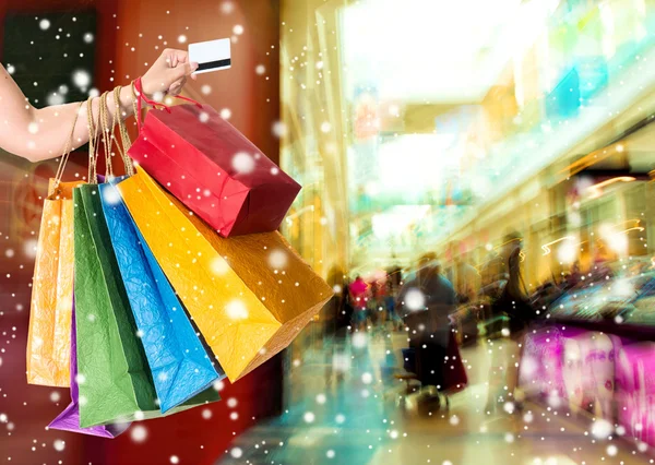 Mulher segurando cartão de crédito e sacos de compras — Fotografia de Stock