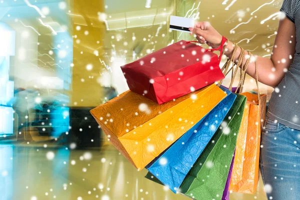 Femme tenant des sacs à provisions et carte de crédit — Photo