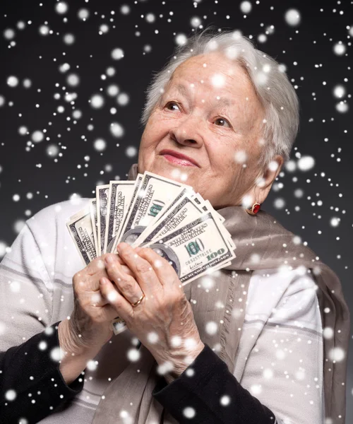 Old woman holding money in hands — Stock Photo, Image