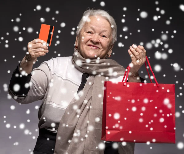 Vieille femme heureuse avec sacs à provisions et carte de crédit — Photo