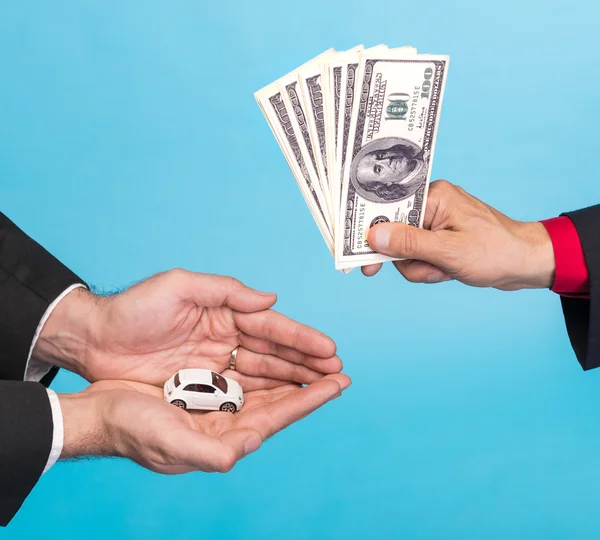 Man holding small car,another man holding dollar bills — Stock Photo, Image