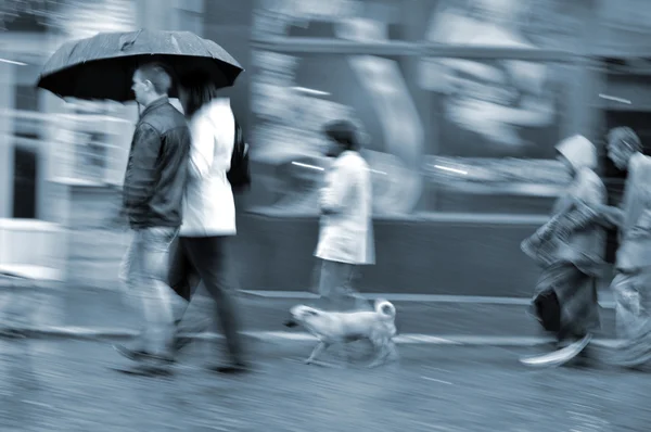 Menschen, die bei Regen die Straße hinunterlaufen — Stockfoto