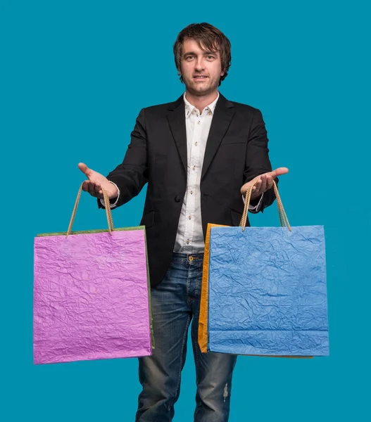 Knappe jongeman met boodschappentassen in shopping mall — Stockfoto