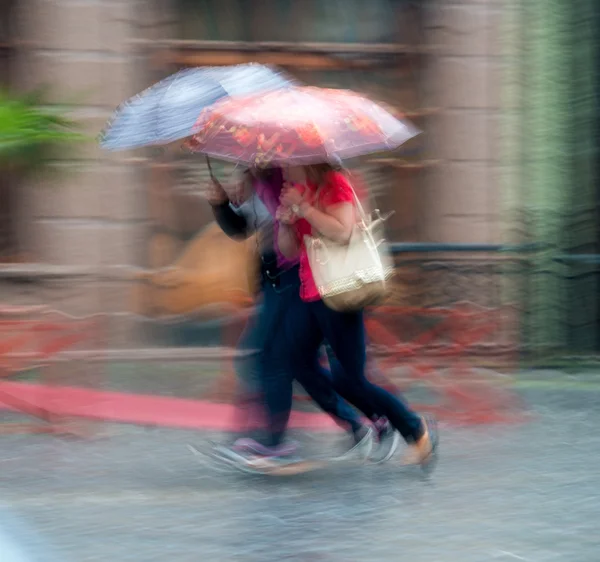 Menschen gehen an einem regnerischen Tag die Straße entlang — Stockfoto