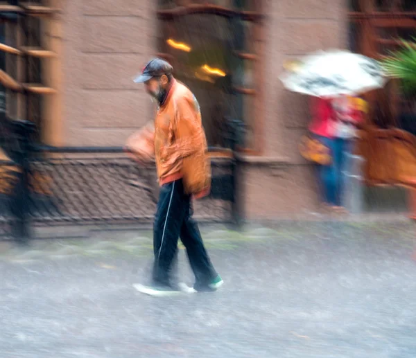 Mann läuft an einem regnerischen Tag die Straße entlang — Stockfoto