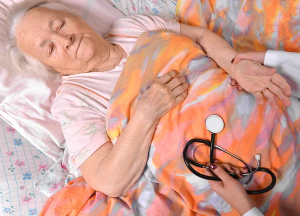 Kadın bekçi yaşlı kadın nabzını kontrol — Stok fotoğraf