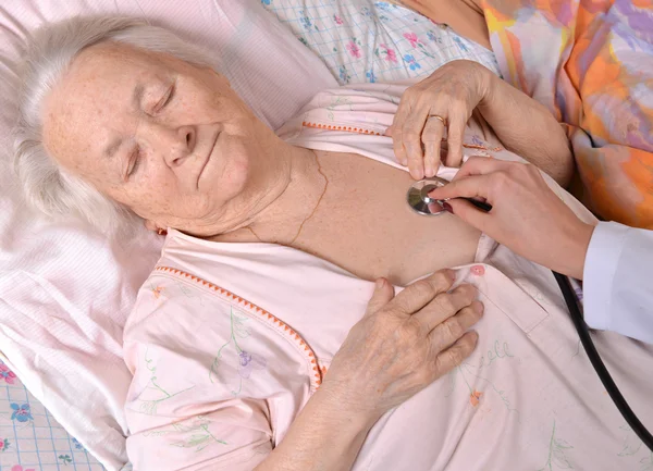 Медсестра, принимающая сердцебиение старухи — стоковое фото