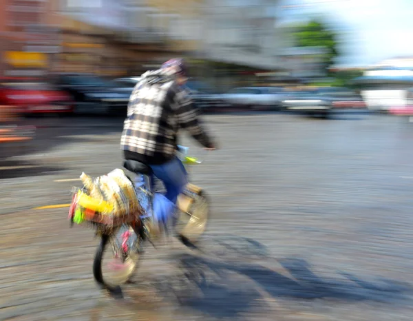 Kobieta na rowerze w ruchu, jazda w dół stree — Zdjęcie stockowe