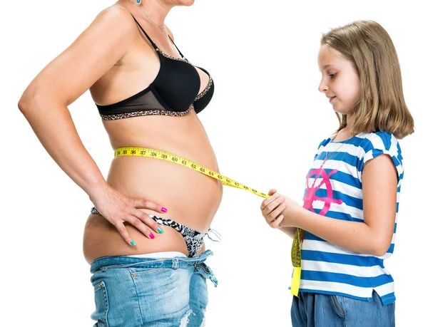 Daughter measuring mother's waistline  with centimeter — Stock Photo, Image