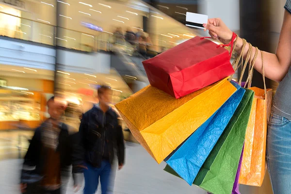 Mulher segurando sacos de compras e cartão de crédito — Fotografia de Stock