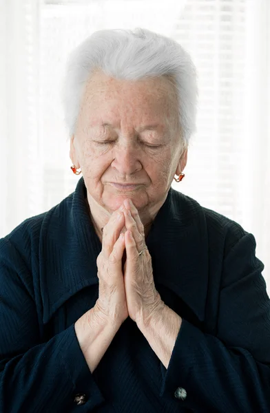 Old woman praying — Stock Photo, Image